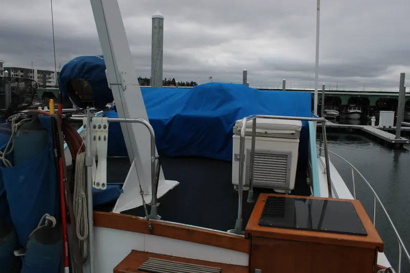 Slide: The Image of 1969 Pacemaker Tricabin yacht docked, covered with blue tarps, overcast sky. - 27