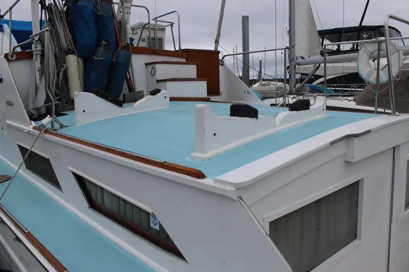 Slide: The Image of 1969 Pacemaker Tricabin boat with blue deck, docked in a marina. - 6