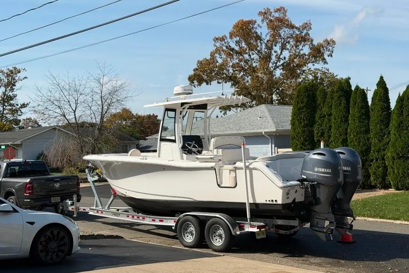 The Image of 2021 Sea Hunt Ultra 275 SE boat on trailer, parked in residential area. - 0