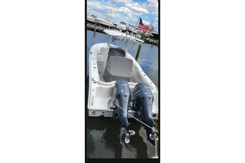 Slide: The Image of 2021 Sea Hunt Ultra 275 SE boat with dual Yamaha engines docked at marina. - 1