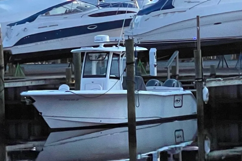 Slide: The Image of 2021 Sea Hunt Ultra 275 SE boat docked at marina, surrounded by other vessels. - 11