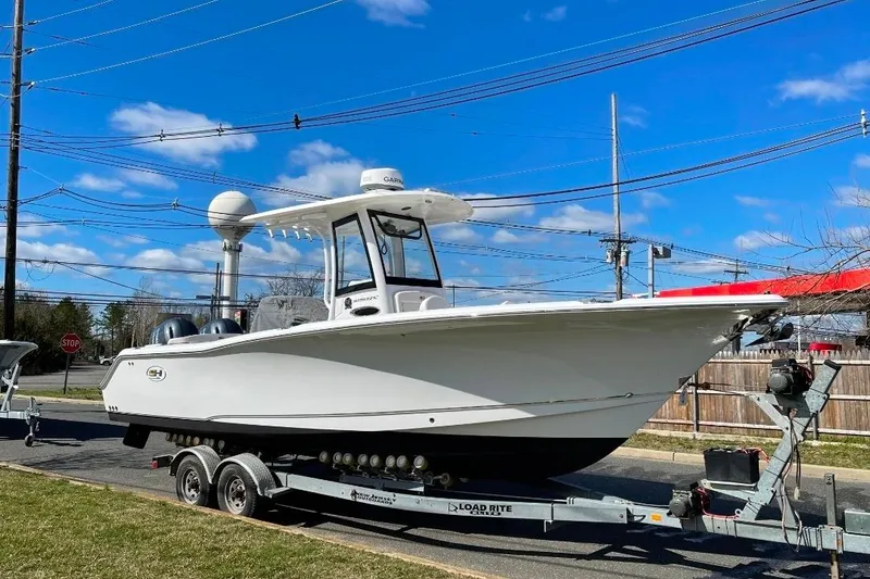 Slide: The Image of 2021 Sea Hunt Ultra 275 SE boat on trailer under clear blue sky. - 13