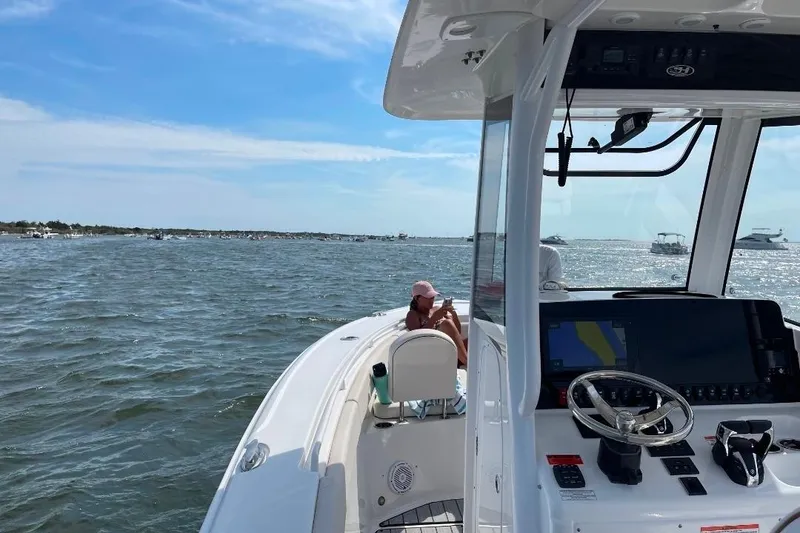 Slide: The Image of 2021 Sea Hunt Ultra 275 SE boat on open water, featuring modern dashboard and scenic view. - 4