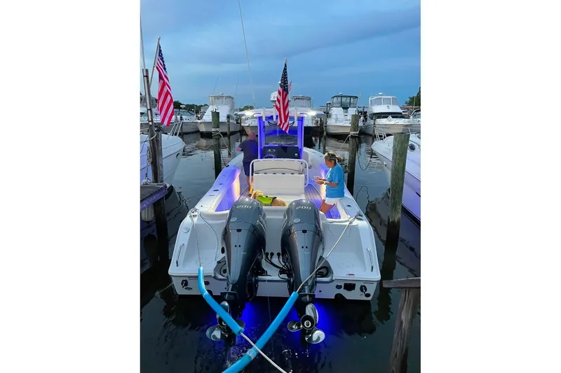 Slide: The Image of 2021 Sea Hunt Ultra 275 SE docked with dual engines and American flags. - 5