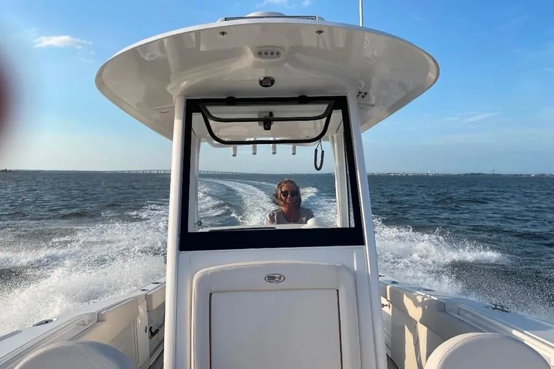 Slide: The Image of 2021 Sea Hunt Ultra 275 SE cruising on open water under clear blue skies. - 7