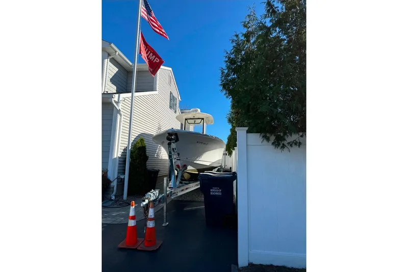 Slide: The Image of 2021 Sea Hunt Ultra 275 SE boat parked in driveway with flags and cones. - 8