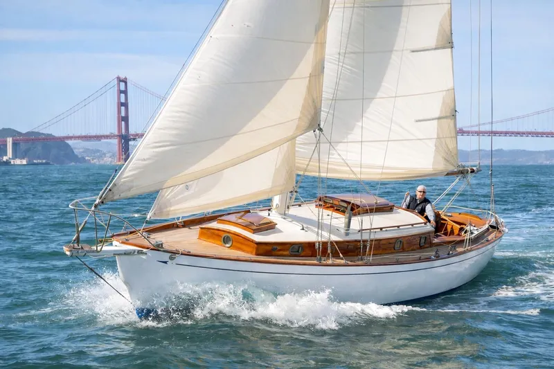 The Image of Vintage 1938 Rhodes Cutter sailboat cruising near Golden Gate Bridge. - 0