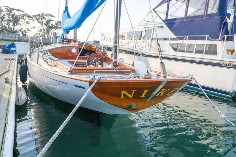 Slide: The Image of Vintage 1938 Philip Rhodes Cutter sailboat docked, showcasing elegant wooden design and classic craftsmanship. - 16