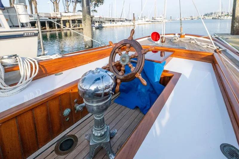 Slide: The Image of 1938 Philip Rhodes Cutter sailboat with wooden deck and classic steering wheel. - 18