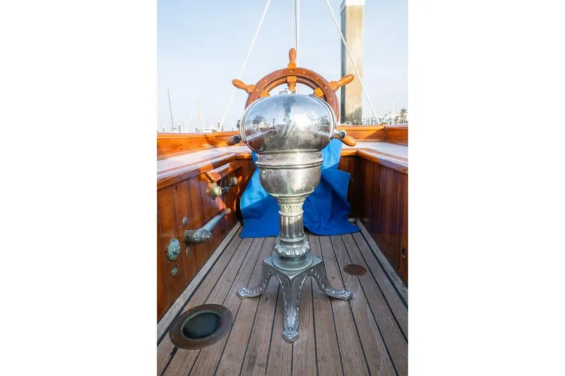 Slide: The Image of 1938 Philip Rhodes Cutter boat helm with polished metal binnacle and wooden deck. - 19