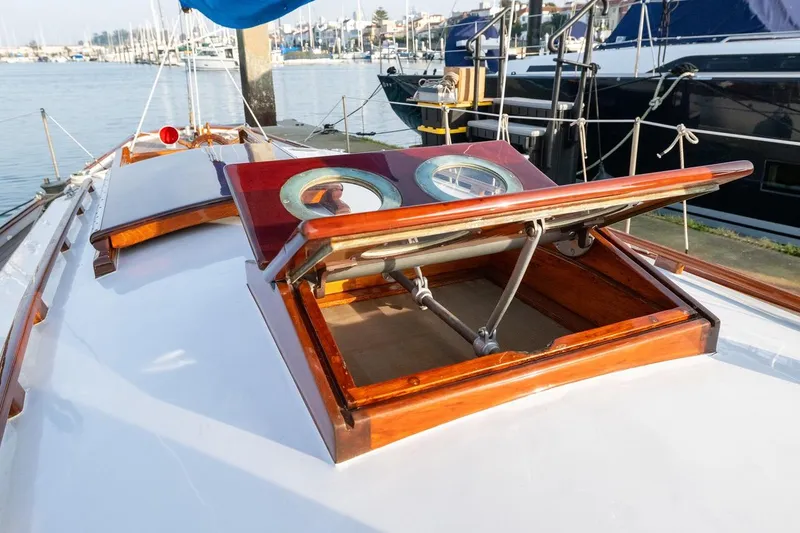 Slide: The Image of 1938 Philip Rhodes Cutter yacht with open wooden hatch, docked in a marina. - 27
