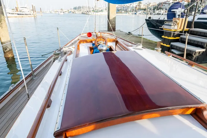Slide: The Image of 1938 Philip Rhodes Cutter sailboat with polished wood deck, docked in a marina. - 29