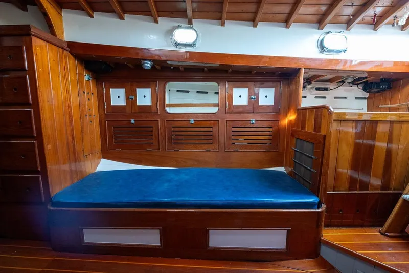 Slide: The Image of 1938 Philip Rhodes Cutter interior with wooden cabinetry and blue cushioned seating. - 37