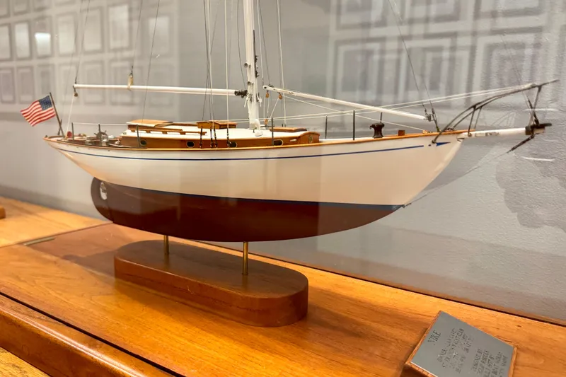 Slide: The Image of Model of 1938 Philip Rhodes Cutter sailboat with American flag, displayed on wooden stand. - 4