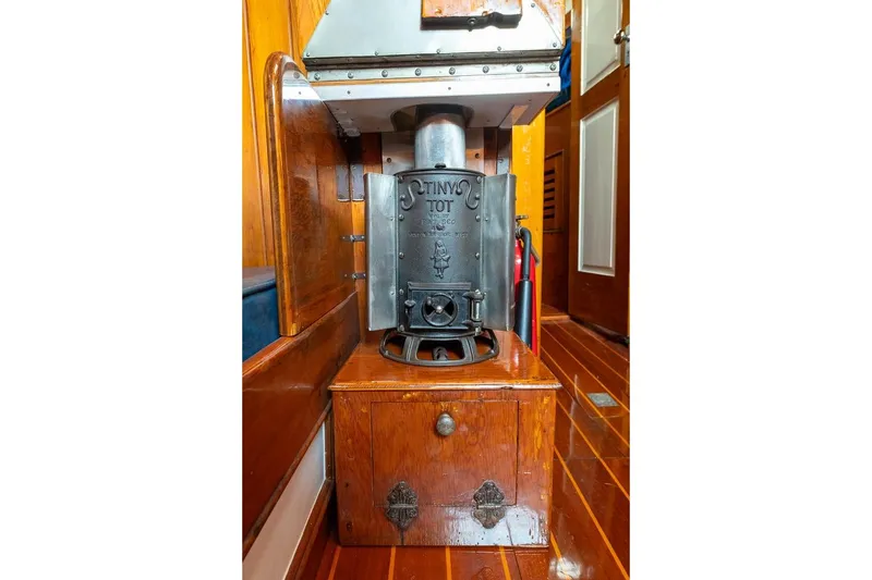 Slide: The Image of Vintage stove inside 1938 Philip Rhodes Cutter boat, featuring wooden interior and classic design. - 42