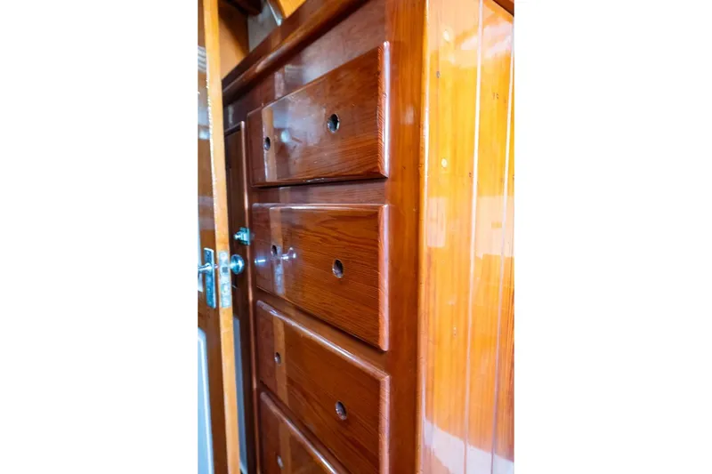 Slide: The Image of Polished wooden drawers inside a 1938 Philip Rhodes Cutter boat. - 49