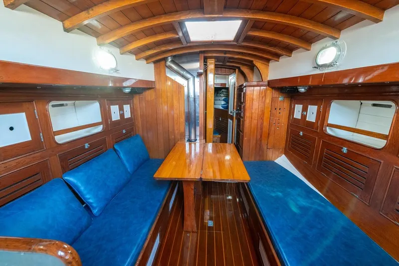 Slide: The Image of Interior of a 1938 Philip Rhodes Cutter, featuring wooden paneling and blue seating. - 51