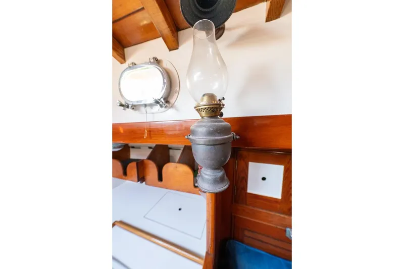 Slide: The Image of Vintage oil lamp inside 1938 Philip Rhodes Cutter boat cabin, with wooden interior details. - 57