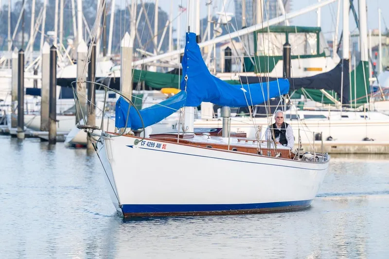Slide: The Image of Vintage 1938 Philip Rhodes Cutter sailboat in marina, featuring blue sail cover. - 6