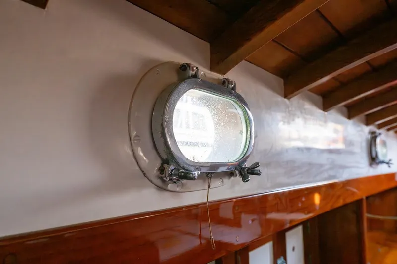 Slide: The Image of Porthole view inside 1938 Philip Rhodes Cutter, showcasing vintage maritime craftsmanship. - 65