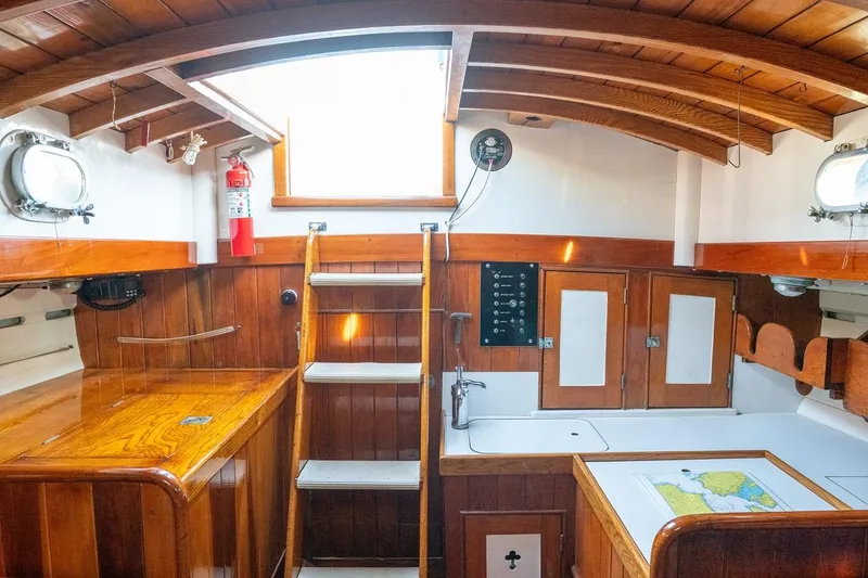 Slide: The Image of Interior of a 1938 Philip Rhodes Cutter, featuring wooden cabinetry and nautical decor. - 66
