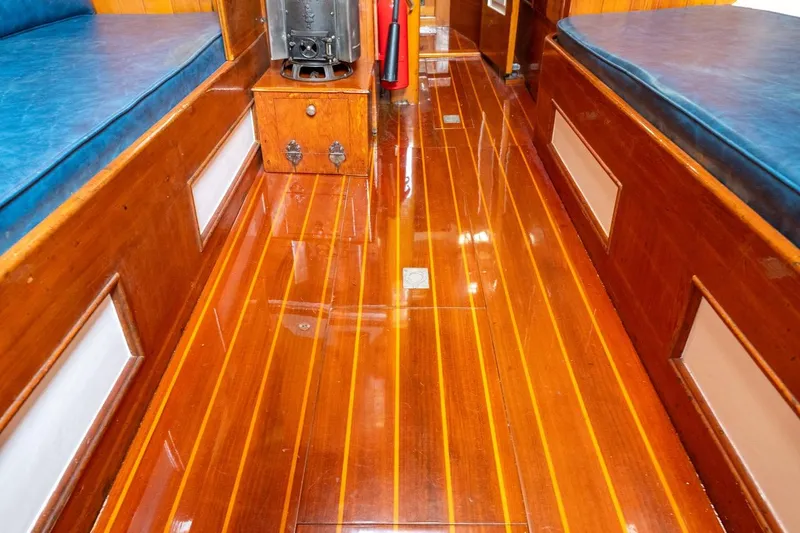 Slide: The Image of Polished wooden interior of 1938 Philip Rhodes Cutter boat, featuring blue cushioned seating. - 68