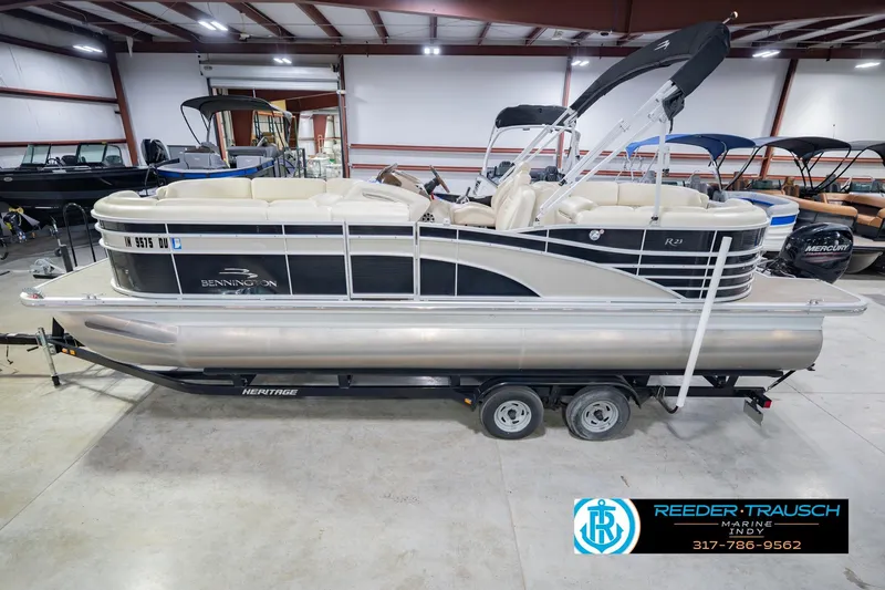 The Image of 2015 Bennington 2350 RSR pontoon boat in showroom, featuring sleek design and comfortable seating. - 2
