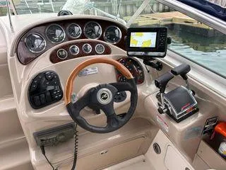 Slide: The Image of Cockpit of 2002 Sea Ray 280 Sundancer with steering wheel and navigation controls. - 11