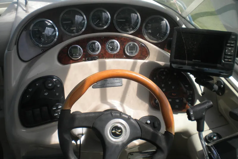 Slide: The Image of Dashboard of a 2002 Sea Ray 280 Sundancer boat with steering wheel and gauges. - 12