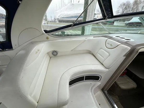 Slide: The Image of Interior of 2002 Sea Ray 280 Sundancer boat with white seating and window view. - 13