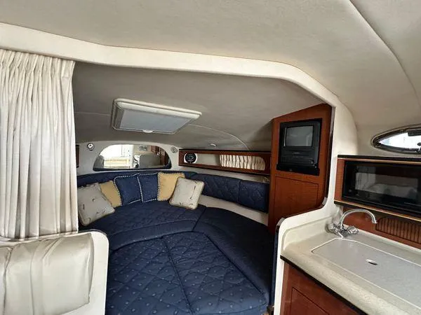 Slide: The Image of Interior of 2002 Sea Ray 280 Sundancer with cozy seating and compact kitchenette. - 19