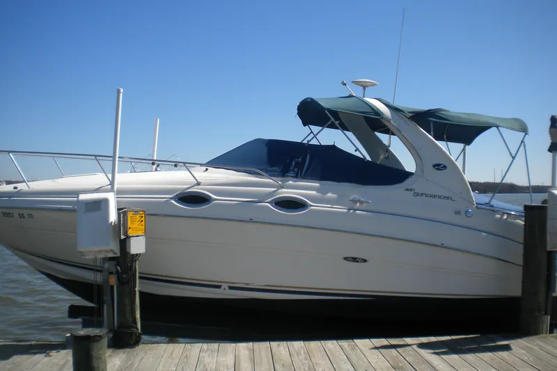 Slide: The Image of 2002 Sea Ray Sundancer 280 docked at a marina under clear blue skies. - 2