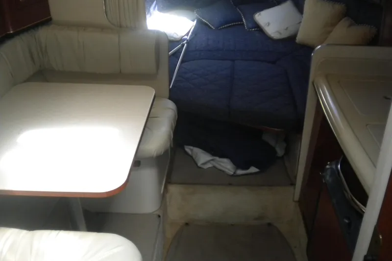 Slide: The Image of Interior of 2002 Sea Ray 280 Sundancer with dining area and cozy sleeping space. - 28