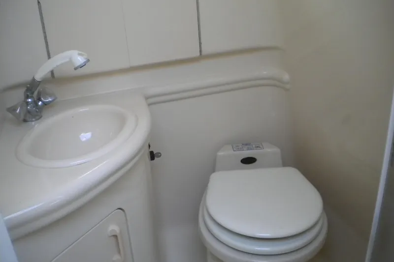 Slide: The Image of Compact bathroom in 2002 Sea Ray 280 Sundancer boat, featuring sink and toilet. - 32