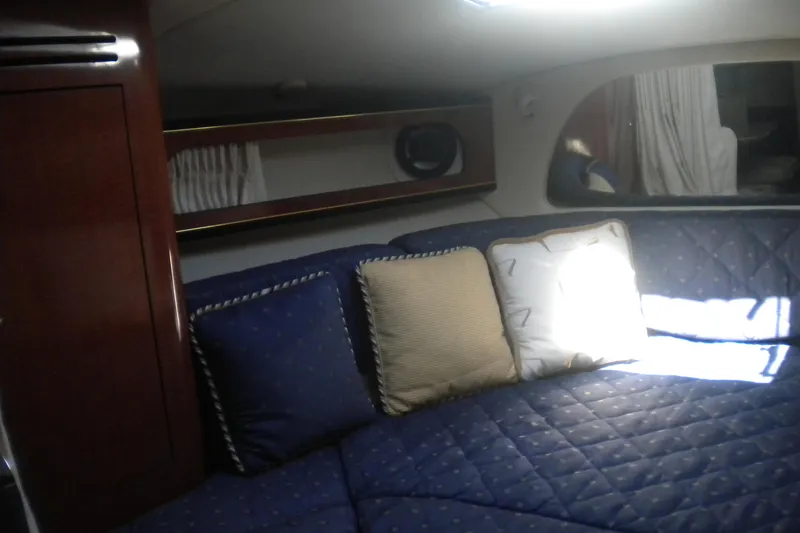 Slide: The Image of Interior of 2002 Sea Ray Sundancer 280 with blue cushioned seating and decorative pillows. - 42