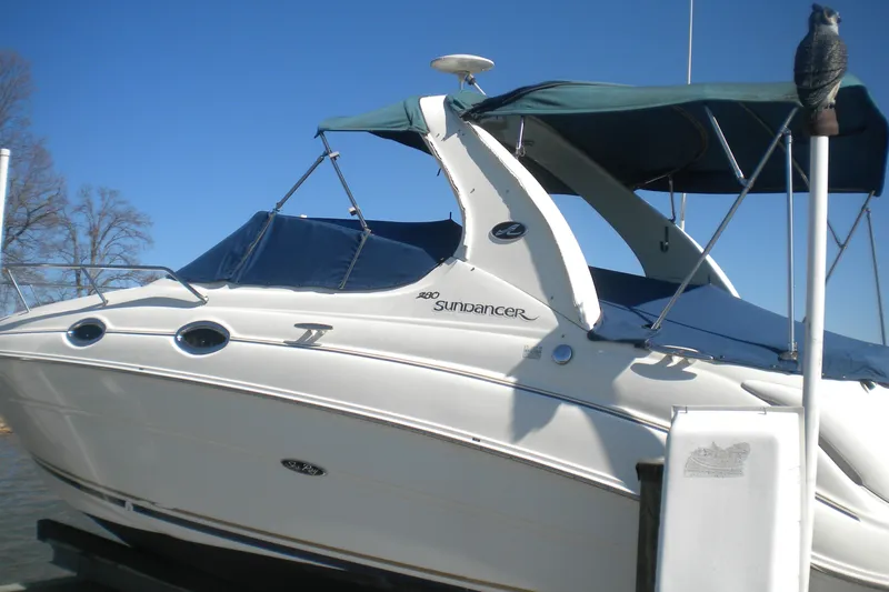 Slide: The Image of 2002 Sea Ray Sundancer 280 boat with blue canopy, docked under clear sky. - 6