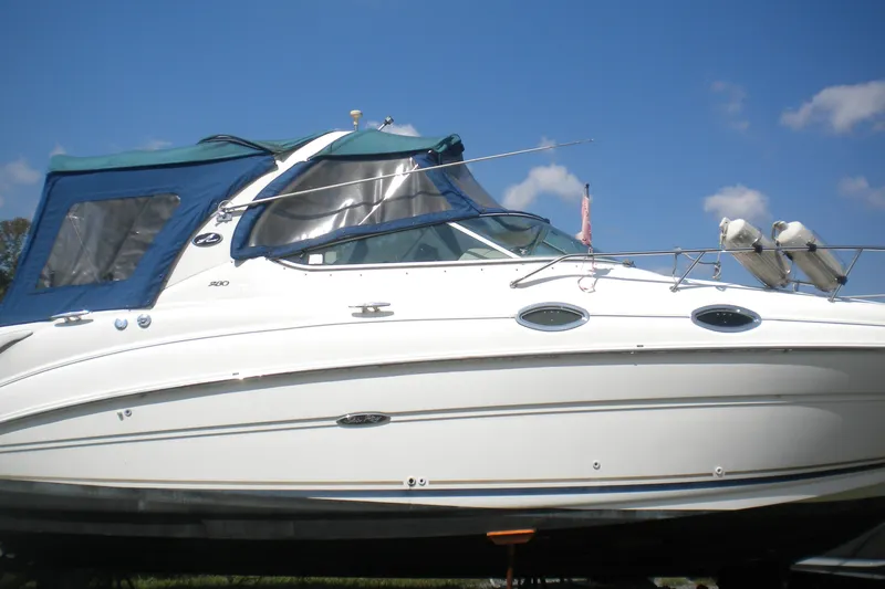 Slide: The Image of 2002 Sea Ray Sundancer 280 boat with blue canopy under clear sky. - 9