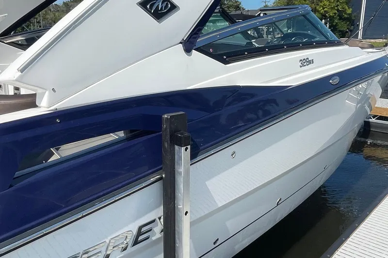 Slide: The Image of 2018 Monterey 328 Super Sport boat docked, featuring sleek white and blue design. - 27