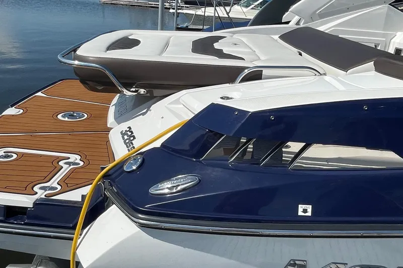 Slide: The Image of 2018 Monterey 328 Super Sport boat docked, featuring sleek design and wooden deck accents. - 28