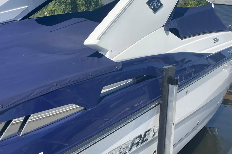 Slide: The Image of 2018 Monterey 328 Super Sport boat with blue cover docked at marina. - 3