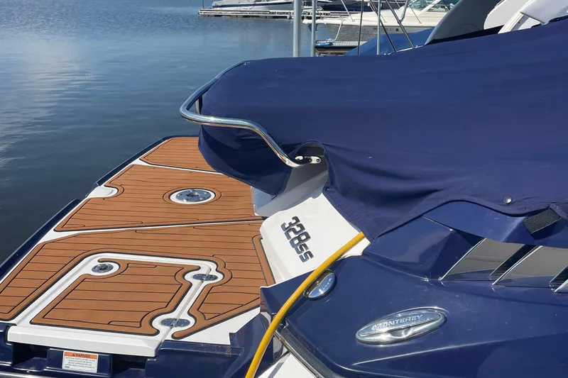 Slide: The Image of 2018 Monterey 328 Super Sport boat with blue cover and wooden deck at marina. - 4