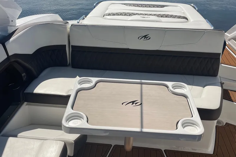 Slide: The Image of 2018 Monterey 328 Super Sport boat interior with cushioned seating and table. - 7