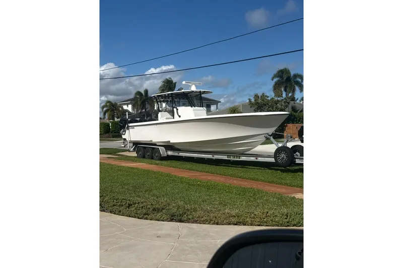 Slide: The Image of 2020 Contender 39 ST boat on trailer, parked in residential area under clear sky. - 9