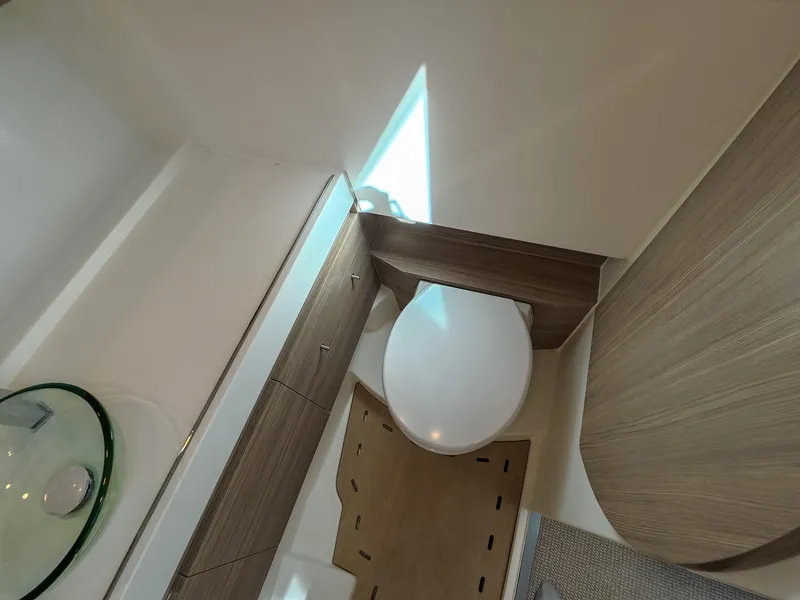 Slide: The Image of The image shows a modern boat bathroom with a toilet and a glass sink. - 17