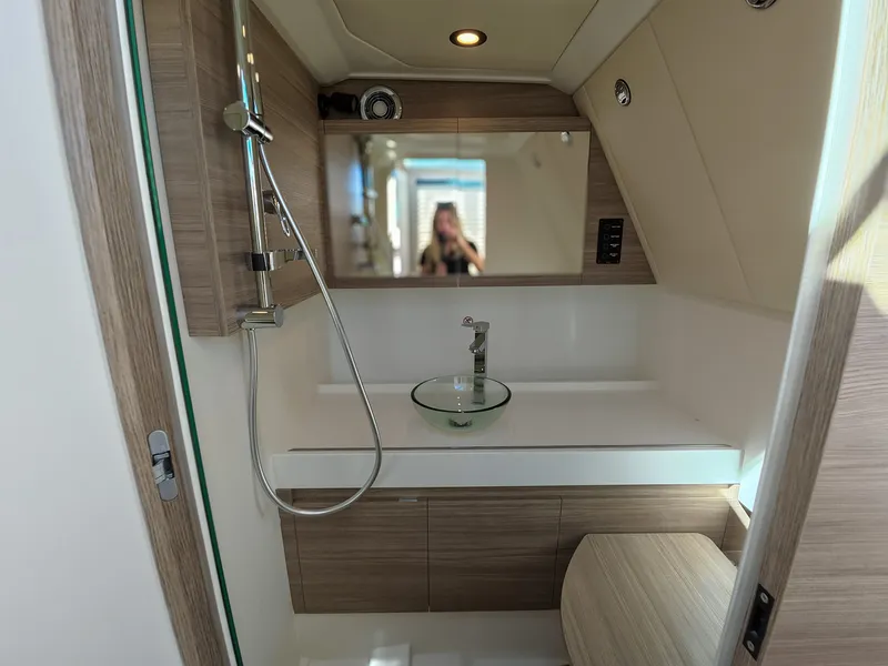Slide: The Image of The image shows a modern boat bathroom with wood paneling and a round sink. - 16