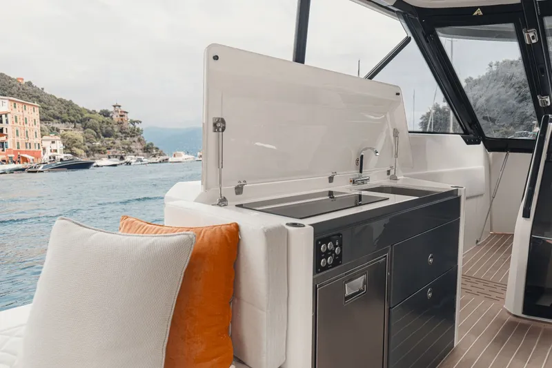 Slide: The Image of The 2027 Saxdor 400 GTO features a modern outdoor kitchen with a sink and cabinets, surrounded by water. - 11