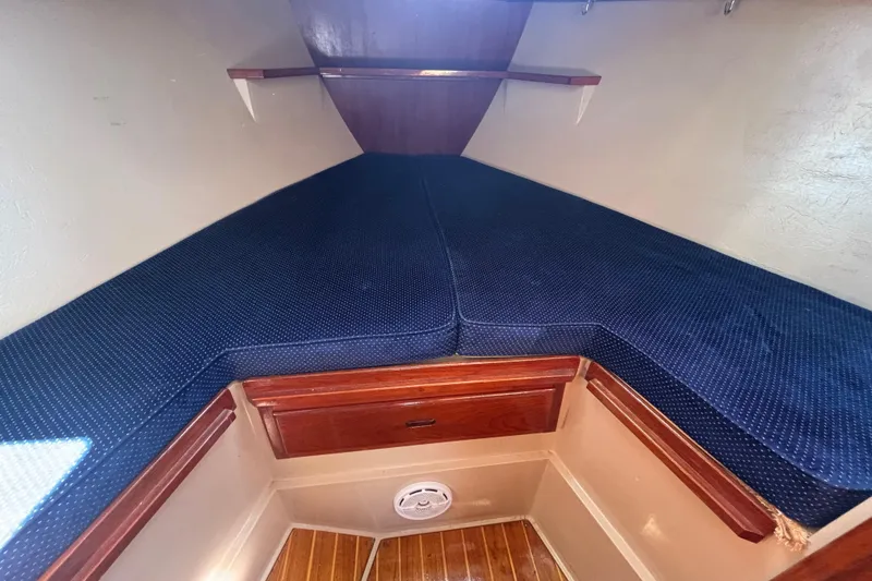 Slide: The Image of 1988 Catalina 34 sailboat interior cabin with blue cushions and wooden accents. - 12