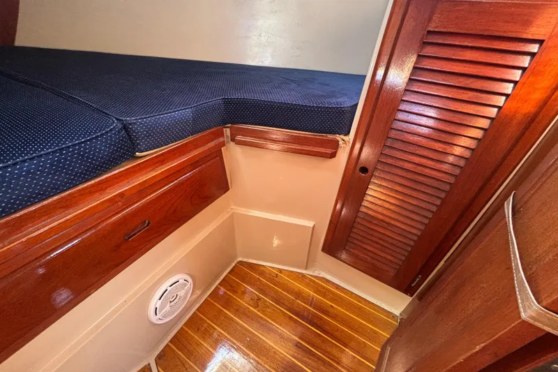 Slide: The Image of Interior cabin of 1988 Catalina 34 sailboat with wooden finish and blue cushions. - 13