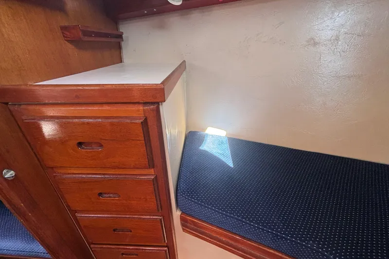 Slide: The Image of Interior of 1988 Catalina 34 sailboat with wooden drawers and blue cushioned seating. - 14