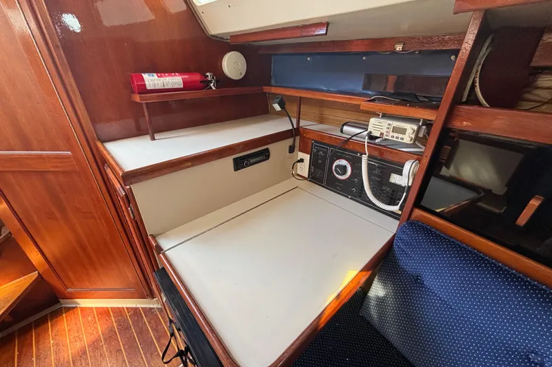 Slide: The Image of 1988 Catalina 34 yacht interior with navigation station and wooden cabinetry. - 16